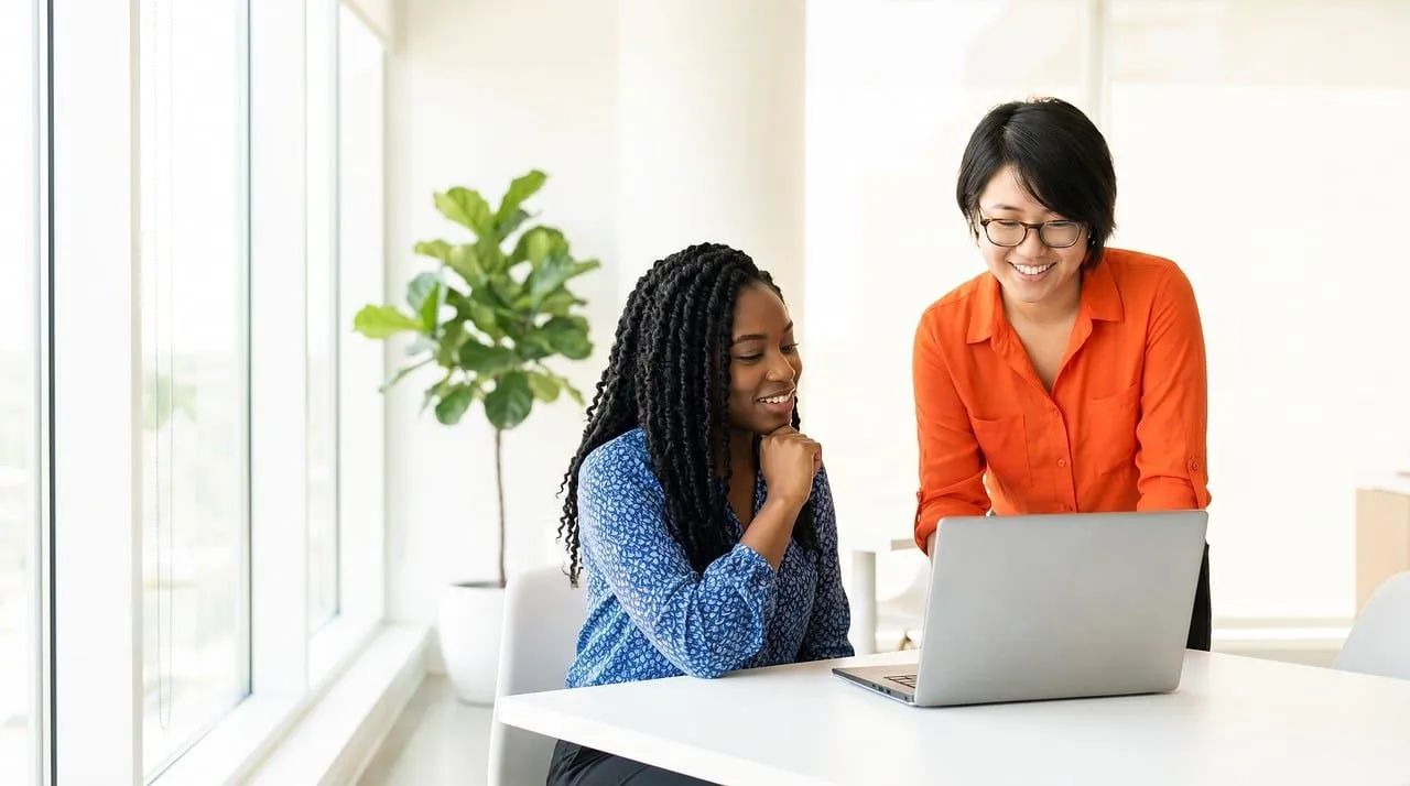 Dos profesionales revisan una estrategia en una laptop